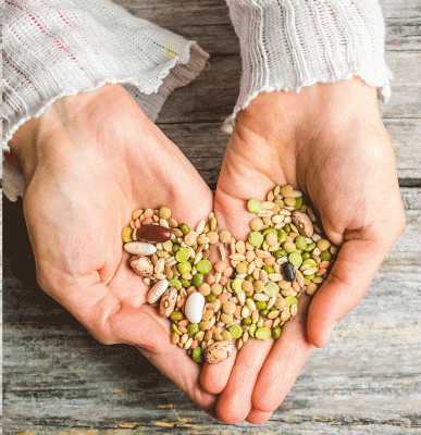 primer-plano-vertical-manos-femeninas-sosteniendo-frijoles-mixtos